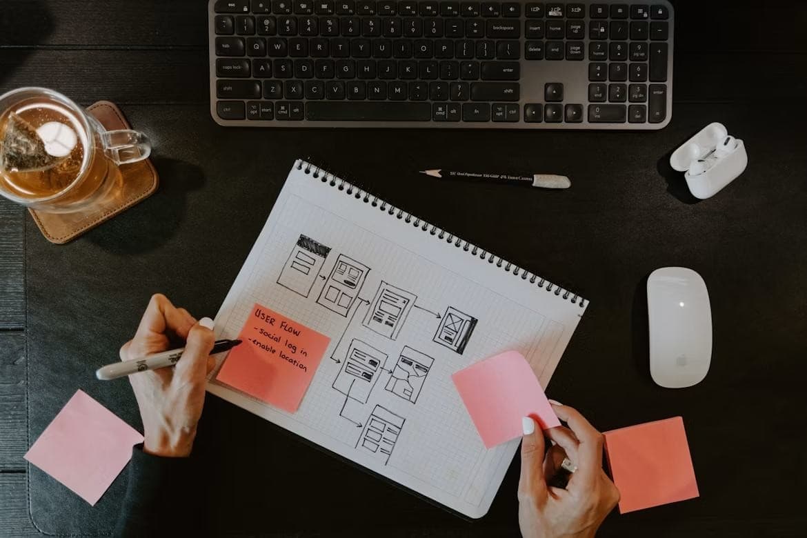 Designer sketching user flows beside a keyboard
